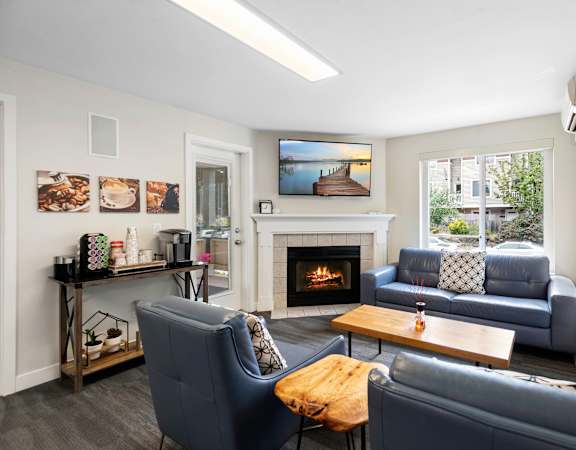 a living room with couches a coffee table and a fireplace at Willows Court Apartment Homes, Washington
