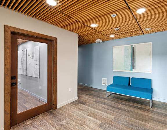 a room with a blue couch and a large painting on the wall at Excalibur, Washington, 98004