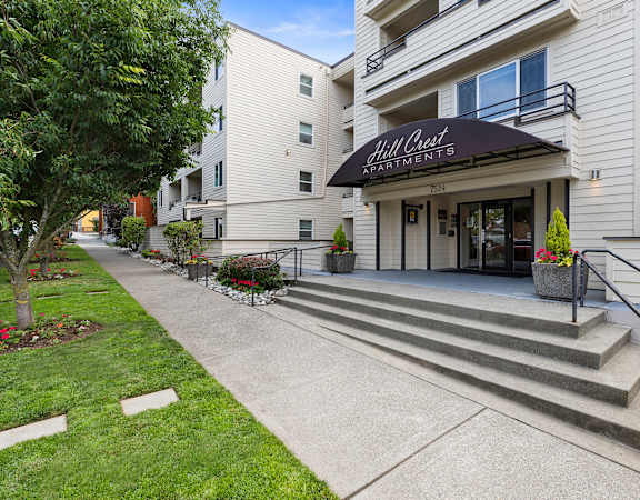 a large white building with a black awning at Hill Crest Apartment Homes, Washington, 98126