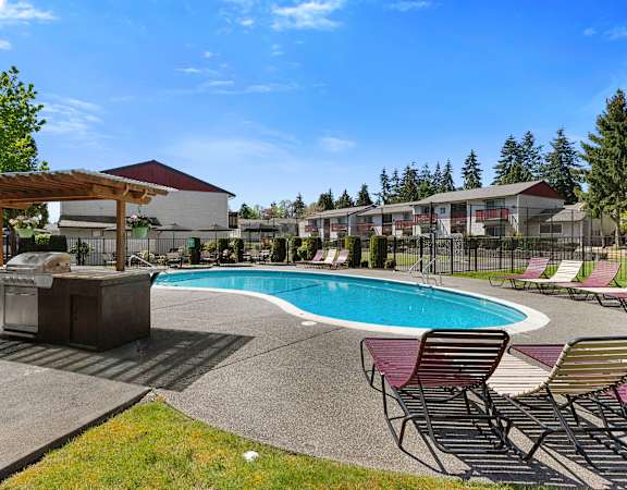 a swimming pool with chairs and a grill next to a hotel pool at Pinewood Square Apartment Homes, Washington, 98087