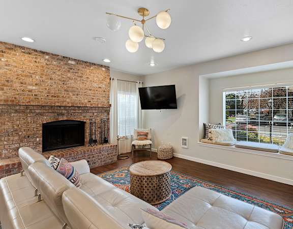 a living room with a fireplace and a large window