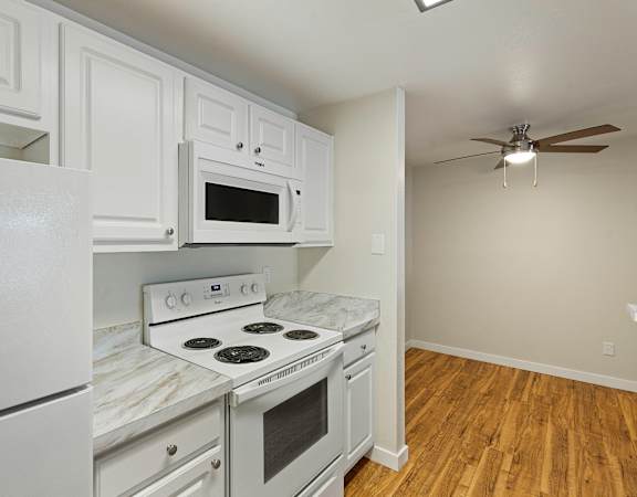 a kitchen with white cabinets and white appliances at Serra Vista Apartment Homes, Washington, 98087