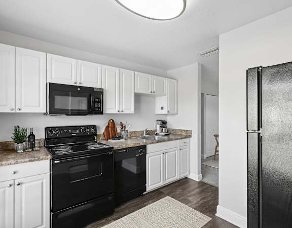 A black and white kitchen with a refrigerator on the right.