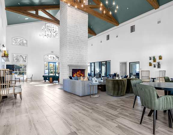 a living room with a fireplace and tables and chairs at Legends at Legacy, Frisco, TX