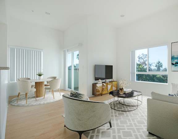 A modern living room with a large couch, a chair, a coffee table, and a television.