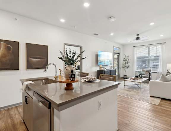an open living room with a kitchen and a living room at The Depot Luxury Apartment Homes, Raymore, MO, 64083