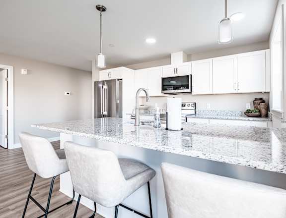 Spacious kitchen island with granite countertops and seating at Windham Village Apartments, Windham