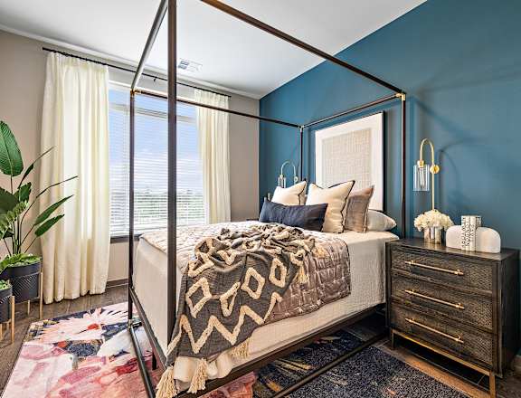 a bedroom with blue walls and a four poster bed  at The Griffin Royal Oak, Royal Oak, Michigan