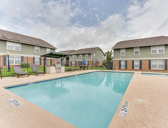 A swimming pool in front of apartment buildings.
