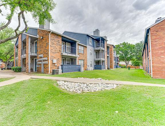 A brick building with a green lawn in front.