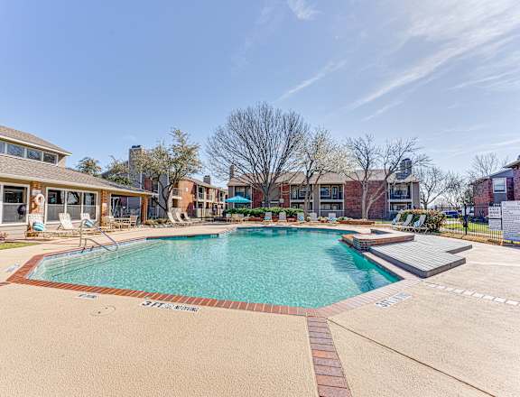 A large swimming pool surrounded by a brick border.