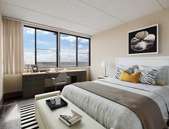 A bedroom with a large bed and a desk with a chair.