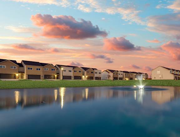 A row of houses are reflected in the water in front of them.