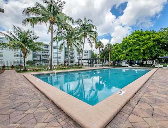a large swimming pool with palm trees in the background  at Club at Emerald Waters, Florida, 33021