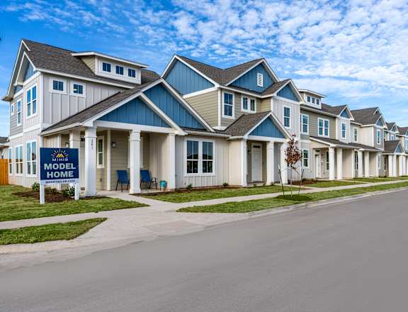townhome exterior with green grass lawn at Mihir Taylor, Taylor