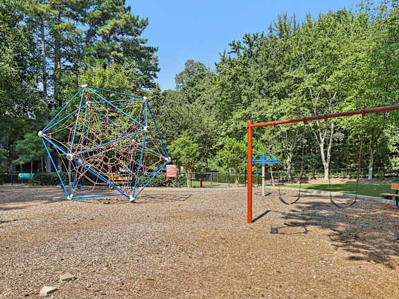 A playground with a swing set and a climbing structure at Canopy Glen, Norcross, Georgia