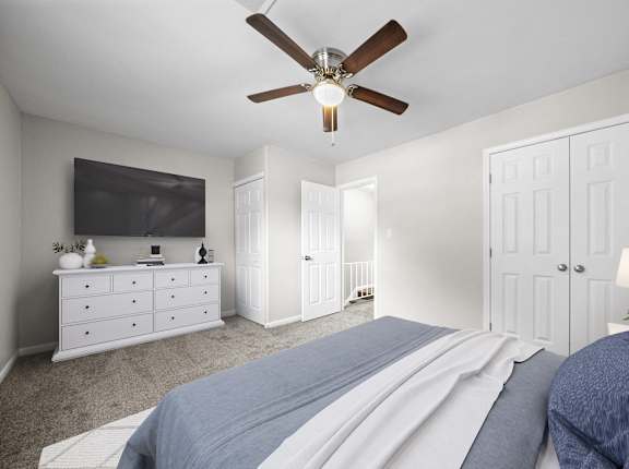 a bedroom with a large bed and a ceiling fan  grass at Georgian Oaks Apartments in Smyrna, GA