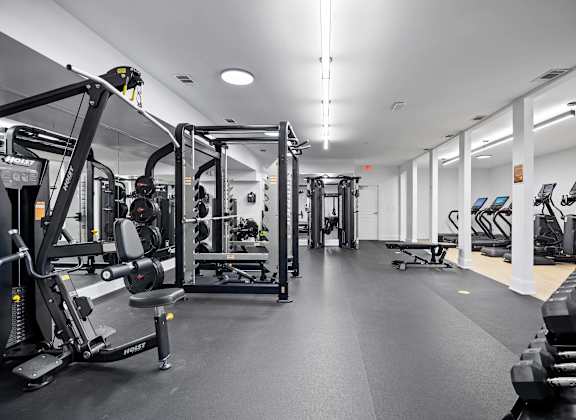 A gym with a variety of equipment including weight machines and free weights.