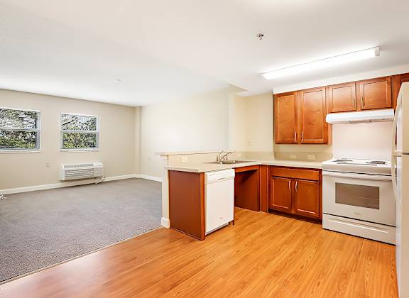 A kitchen with wooden floors and white appliances.