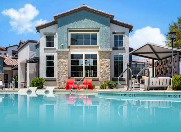 A large house with a pool in front.