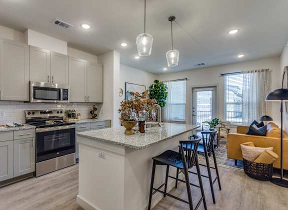 A modern kitchen with a large island and a dining area.