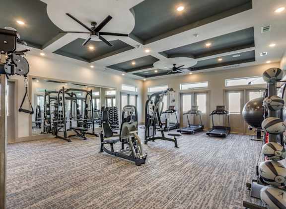 A spacious gym with a variety of equipment including treadmills, weights, and exercise machines.
