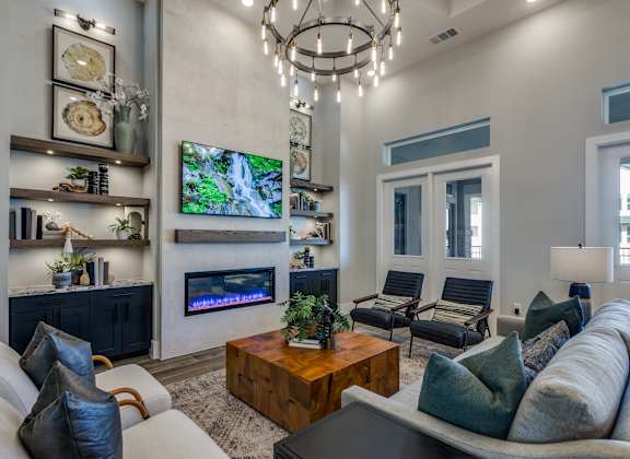 A modern living room with a fireplace and a flat screen TV mounted on the wall.