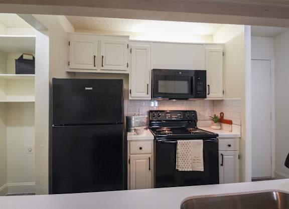 a kitchen with black appliances and white cabinets