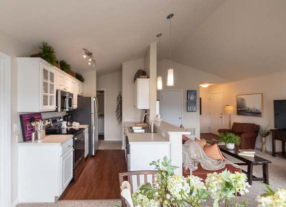 a view of a living room and a kitchen with a table and chairs