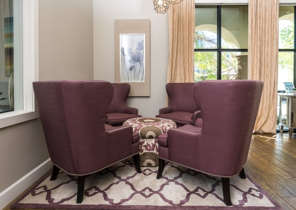 a living room with two purple chairs and a coffee table