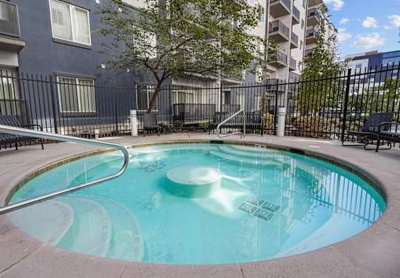 A small pool with a metal fence around it.