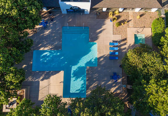 an aerial view of a swimming pool with a blue cross on it