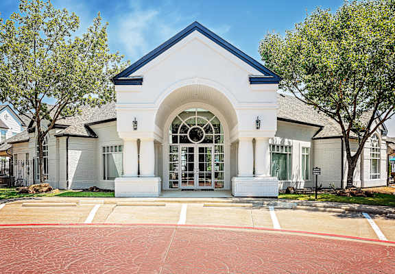 A white building with a black roof and a large arched entrance.