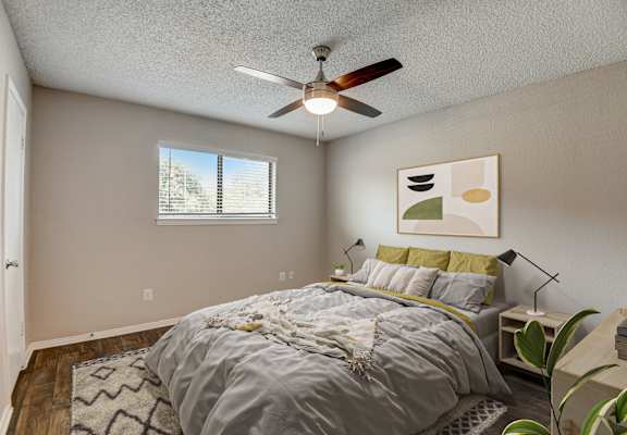 a bedroom with a large bed and a ceiling fan