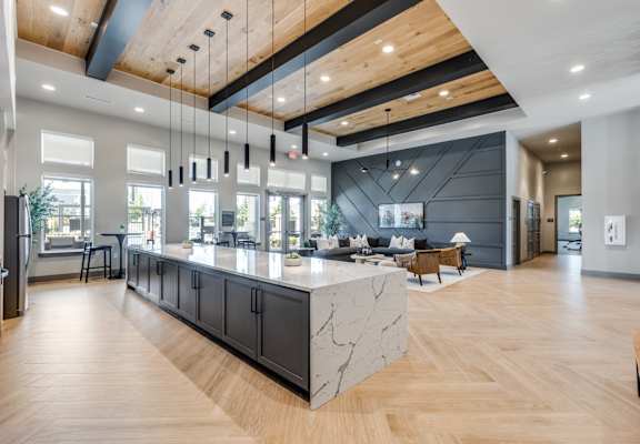 A modern kitchen with a marble island and wooden floors.