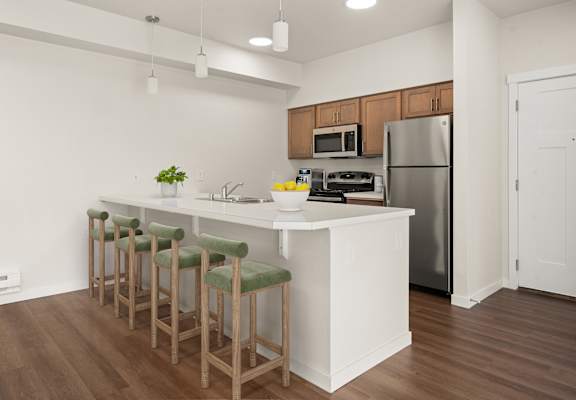 A kitchen with a white island and green bar stools.