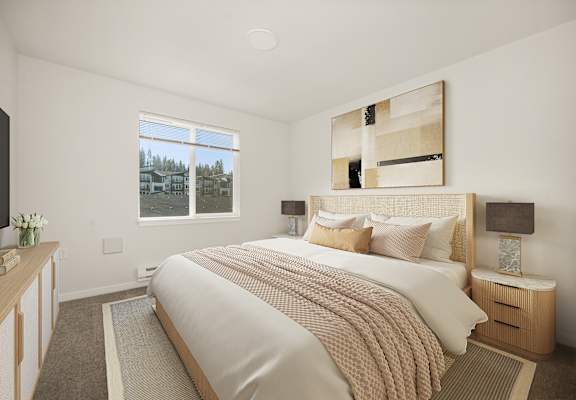A bedroom with a large bed and a window overlooking a residential area.