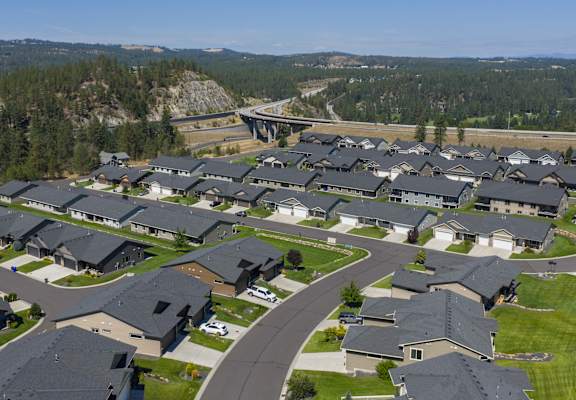 A suburban neighborhood with houses and a bridge in the background.