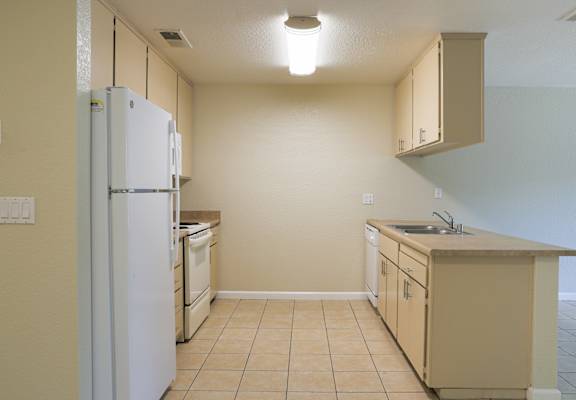an empty kitchen with a refrigerator and a sink at Creekview Homes, Chico, 95928