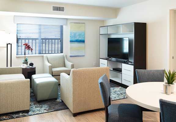 a living room with chairs and a table and a television at Parks Residential - Richardson, Richardson, 75082