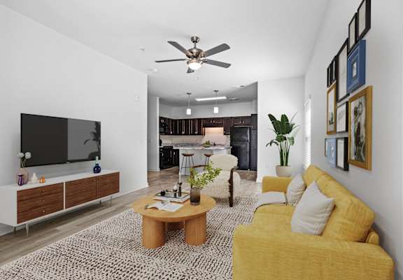 a living room with a yellow couch and a tv