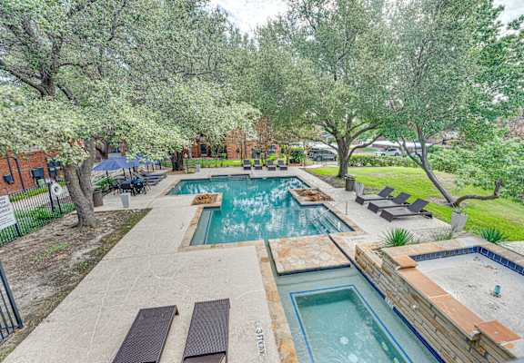 a backyard with a swimming pool and trees at Indian Creek Apartments, Carrollton, 75007