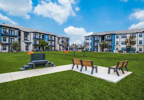 a park with benches in front of an apartment building  at Valor at Harlingen, Harlingen, TX, 78552