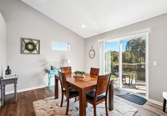 A dining room with a wooden table and chairs.