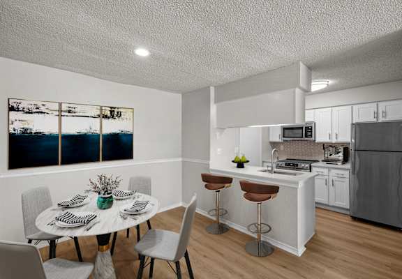A modern kitchen with a dining table set for four.