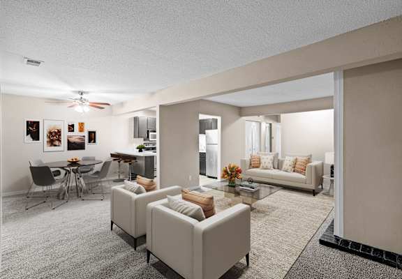 A living room with a grey carpet and a white ceiling fan.