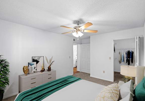 a bedroom with a large bed and a ceiling fan
