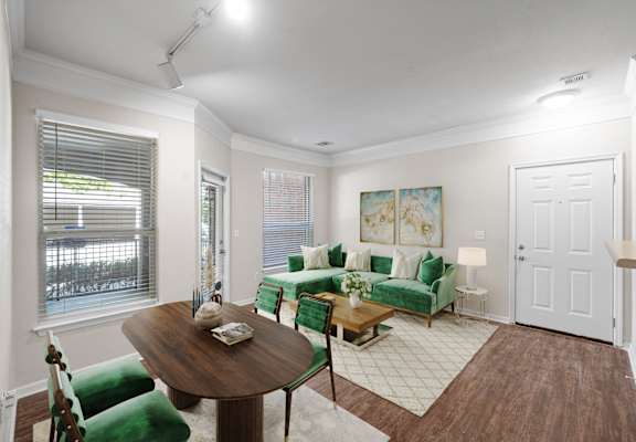 A living room with a green couch and a wooden table. at Somerset Oaks Apartment Homes, Olathe