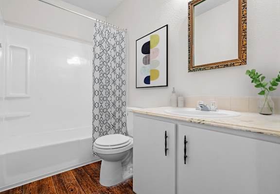 A bathroom with a toilet, sink, and shower curtain.