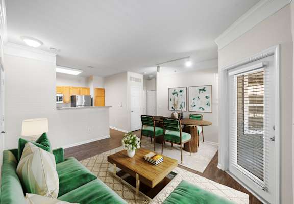 A living room with a green couch and a coffee table. at Somerset Oaks Apartment Homes, Olathe